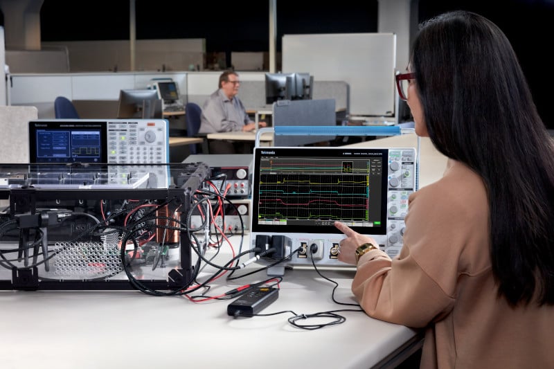 Engineer using an arbitrary function generator and 4 Series B MSO oscilloscope with double pulse testing software to perform a double pulse test on a half bridge power circuit