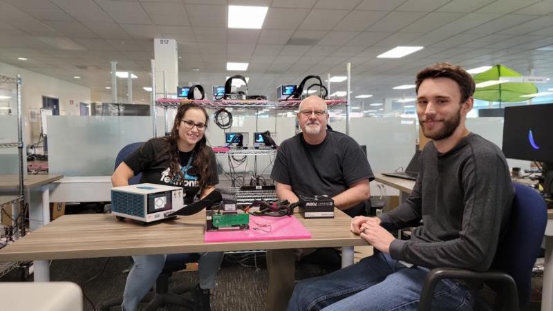 Tektronix employees sitting next to the TMT4 Margin Tester