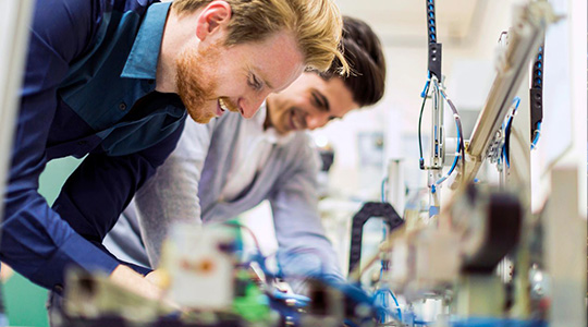 University engineering students working together using a lab power supply for testing