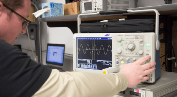 Technician calibrating an oscilloscope