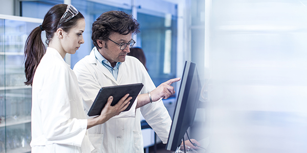 Two medical researchers in a laboratory setting engaged in an experiment data analysis