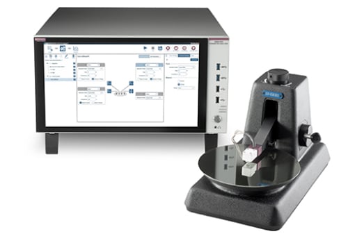 Laboratory setup featuring a probe station with a wafer and a Keithley instrument displaying a resistivity measurement.